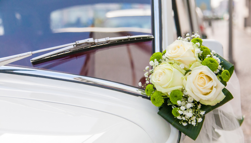 voiture de collection avec un bouquet de mariage sur le rétroviseur